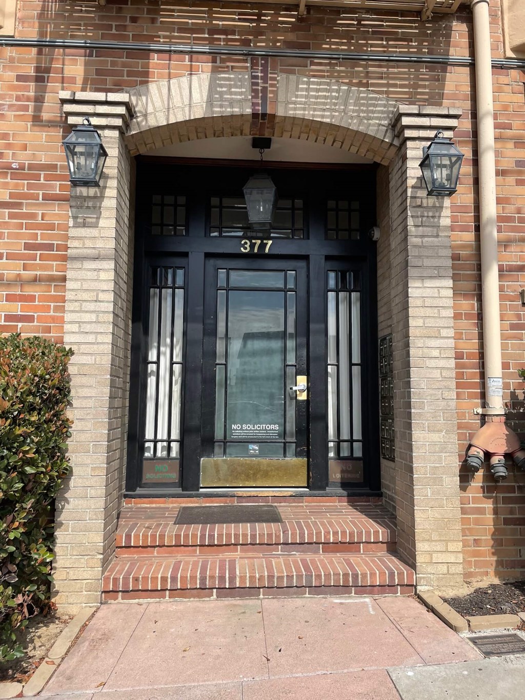 the front door of a brick building with black doors